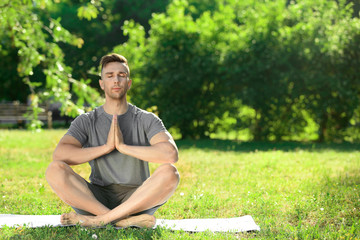 Sporty man practicing yoga in park