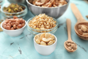 Bowls and spoons with different nuts on table