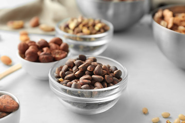 Bowl with tasty pine nuts on table