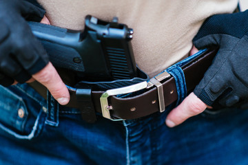 the guy puts the gun in the holster close-up