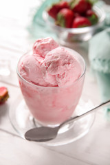 Glass with tasty strawberry ice cream on table