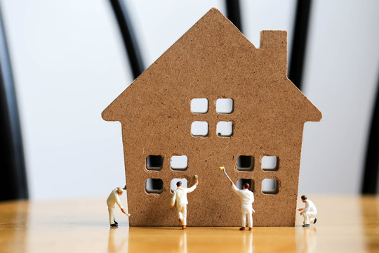 Miniature people : worker team with House and clock,concept of construction site.