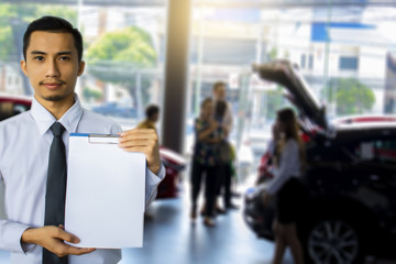 Asian business man on car showroom and people blurry background.Metaphor for .Buying car to...
