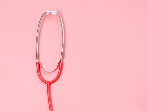 Stethoscope on pink background, copy space.