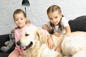 portrait of adorable kids with golden retriever dog at home