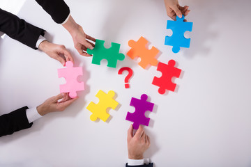 Group Of Businesspeople Holding Jigsaw Puzzle
