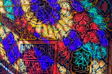Obraz na płótnie Canvas Colorful light from stained glass window on the wall of Nasir Ol-Molk mosque, also famous as Pink Mosque. Shiraz. Iran