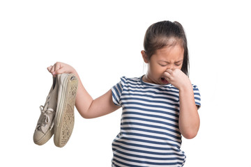 Asian kid girl age 7 year hold stinky shoe on white background - obrazy, fototapety, plakaty
