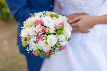 Wedding bouquet of flowers including Red hypericum, Roses, Lilies of the valley, mini Roses, Seeded Eucalyptus, Astilbe, Scabiosa, Pieris, and ivy