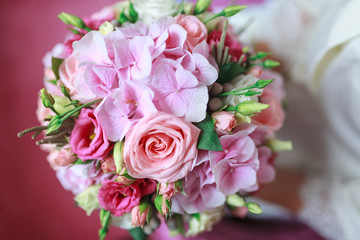 Wedding bouquet of flowers including Red hypericum, Roses, Lilies of the valley, mini Roses, Seeded Eucalyptus, Astilbe, Scabiosa, Pieris, and ivy