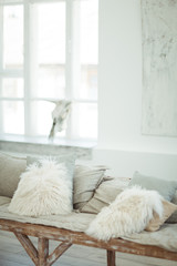 A self-made sofa with light soft pillows in a light-white interior