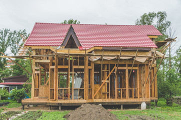 Fototapeta na wymiar construction of a frame house, metal roof