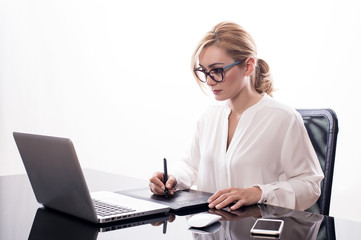 Donna d'affari seduta alla scrivania con tavoletta grafica su fondo bianco - 210283835