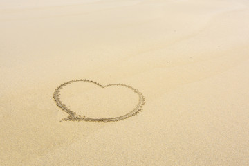 Fototapeta na wymiar corazón dibujado en la arena de la playa 