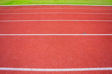 White lines of stadium and texture of running racetrack red rubber racetracks in outdoor stadium are 8 track and green grass field,empty athletics stadium with track,football field, soccer field.