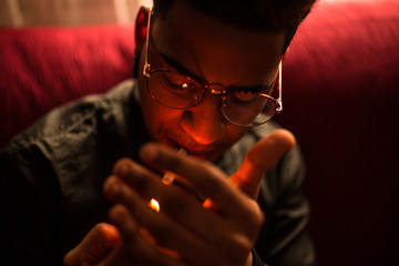 Black man lighting cigarette
