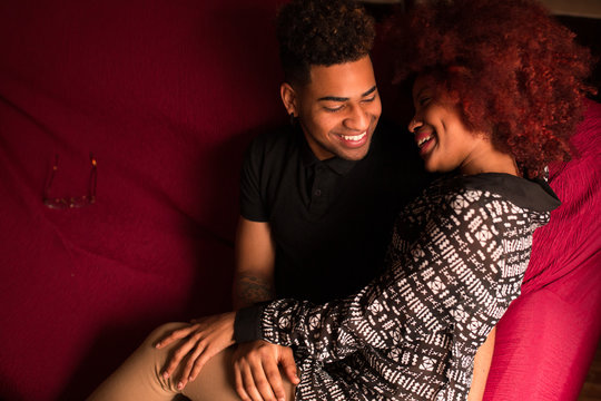 Embracing happy black couple on couch