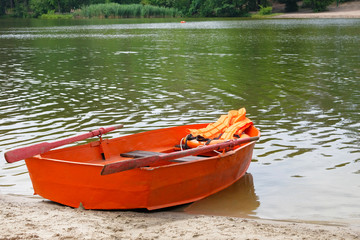 Outfit of lifeguard on water in summer boat, life jacket, lifebuoy in orange color. Help in water.