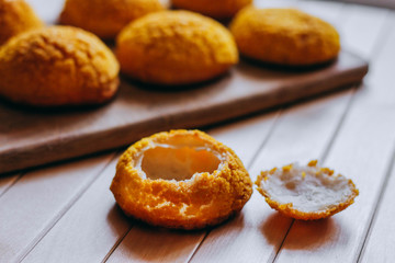 Close-up of Shu cream (Japanese cream puff), red velvet cake, chocolate cake, and hot coffee on wooden table in outdoor garden. Concept sweets enjoy eating.