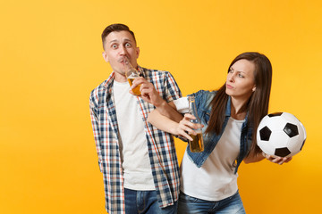 Young happy cheerful couple supporter, woman man, football fans cheer up support team, holding beer bottle, soccer ball isolated on yellow background. Sport, family leisure, people lifestyle concept.