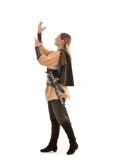 full length portrait of girl wearing medieval costume with sword. standing pose with back to the camera, isolated on white studio background.