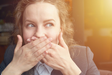 Woman giggles covering her mouth with hand
