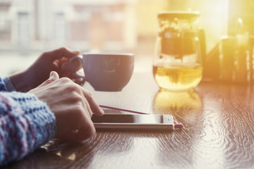 Woman in cafe holding smart phone. For Graphic display montage.
