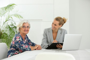 businesswoman having financial meeting with retired customer