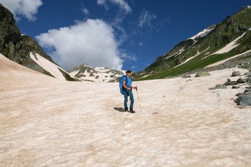 Tourist walking on snow in the Caucasus mountains