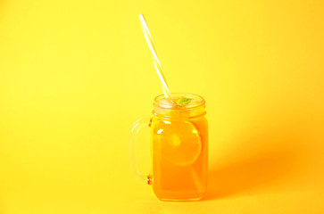 Colorful composition with vintage mason jar glass full of fresh orange juice based non alcoholic...