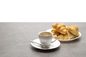 Cup of fresh coffee with croissants on dark background