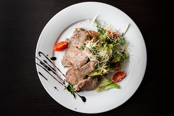 European international fusion cuisine, a beautiful dish on a white plate decorated with herbs and vegetables. a professional chef has prepared a delicious meal.