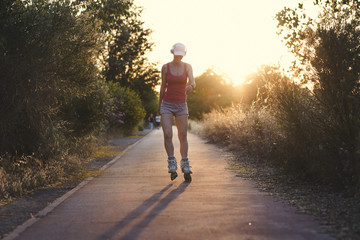 Young sportswoman having  fun while roller skating and listening music