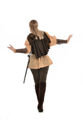 full length portrait of girl wearing medieval costume with sword. standing pose with back to the camera, isolated on white studio background.