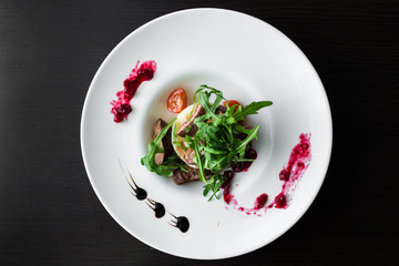 European international fusion cuisine, a beautiful dish on a white plate decorated with herbs and vegetables. a professional chef has prepared a delicious meal.