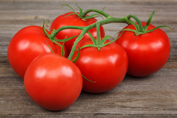 Branch fresh red tomato on a wooden background