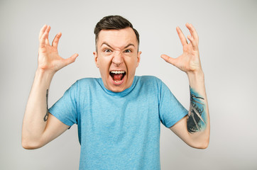 Young guy in fury, dressed in a blue t-shirt on a light background.