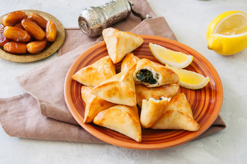 Arabic and middle eastern food concept. Fatayer sabanekh - traditional arabic spinach triangle hand...