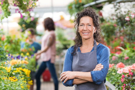 Stolz l&auml;chelnde Floristin in ihrem Blumengesch&auml;ft
