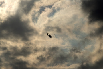 Fototapeta na wymiar Helicopter, flying in cloudy evening light