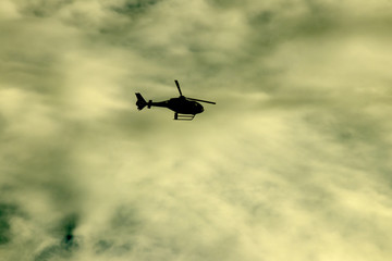 Helicopter, flying in cloudy evening light
