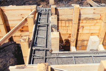 house industrial construction site, cement in foundation and reinforcement of steel bars