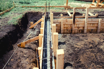 new house, building construction site, cement in foundation and reinforcement of steel bars
