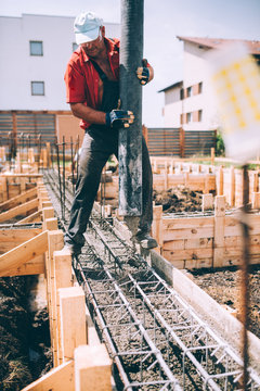 industrial worker using concrete pump for building house foundation. Details of constuctor on construction site