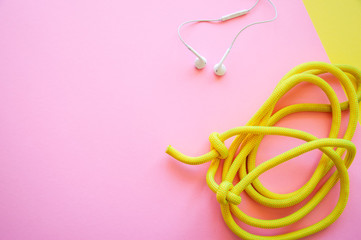 Skipping rope on a pink and yellow background. Top view and copy space. Sport, hobby and lifestyle concept.