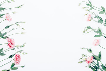 Floral flat lay frame of pink flowers on white background