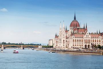 Obraz premium a classic view of the famous tourist attraction of Budapest - the Hungarian Parliament and the Danube River with ships