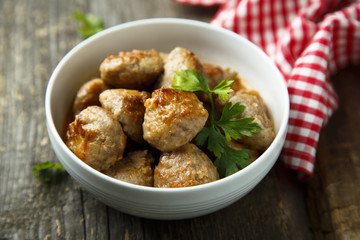 Homemade meatballs with fresh parsley in a white bowl