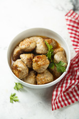 Homemade meatballs with fresh parsley in a white bowl