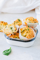 Savory potato spinach and feta muffins. White stone background.